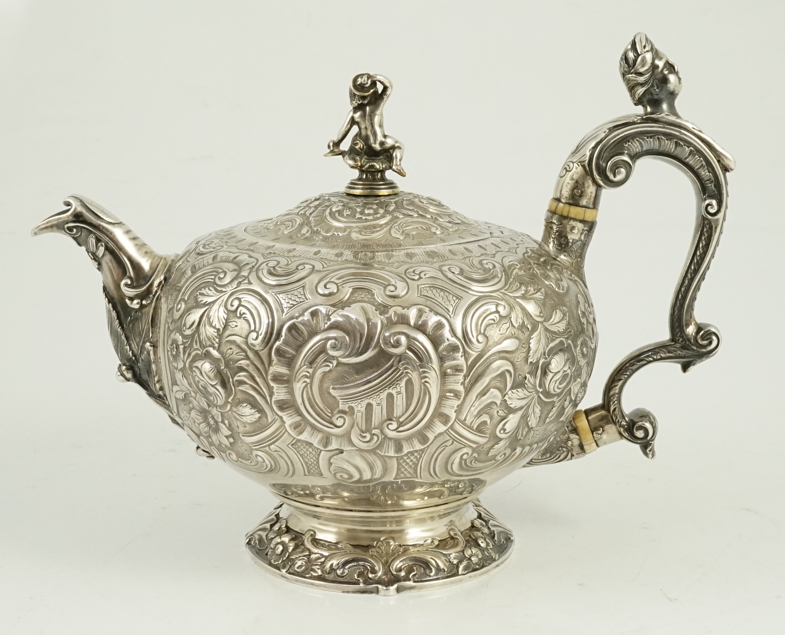 A George III silver rococo style inverted pear shaped pedestal teapot by Robert Garrard I